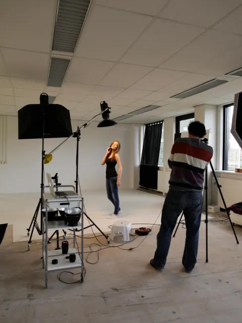 Stefan Segers fotografeert een vrouwelijk model met studioverlichting in een lege ruimte op locatie