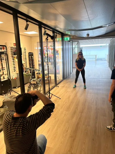 Stefan Segers fotografeert een model in een moderne winkelruimte op locatie