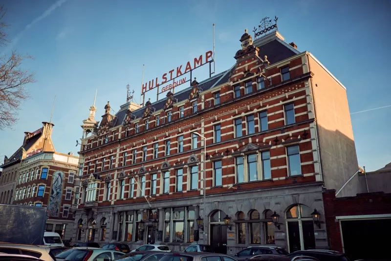Historisch bakstenen pakhuis met het opschrift Hulstkamp op de gevel onder een blauwe lucht